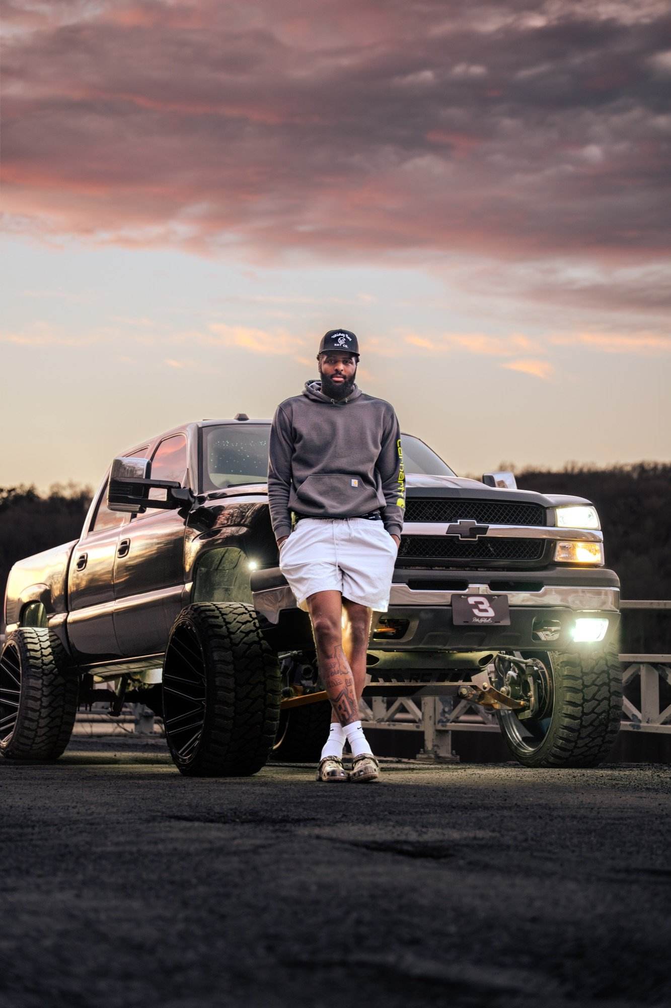 The Cateye — lifted Chevy Silverado by a white fence at golden hour
